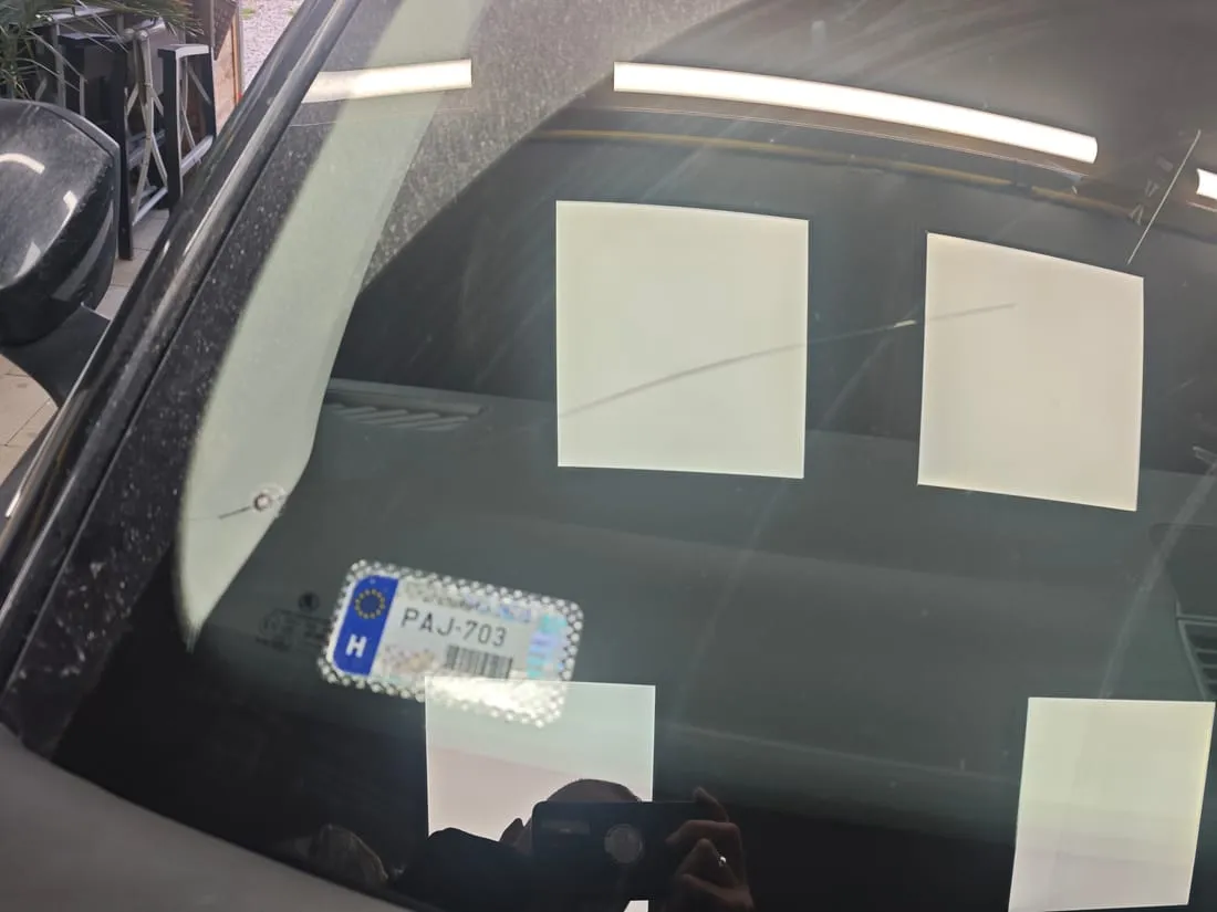 Kőfelverődés okozta repedés egy autó szélvédőjén közelről